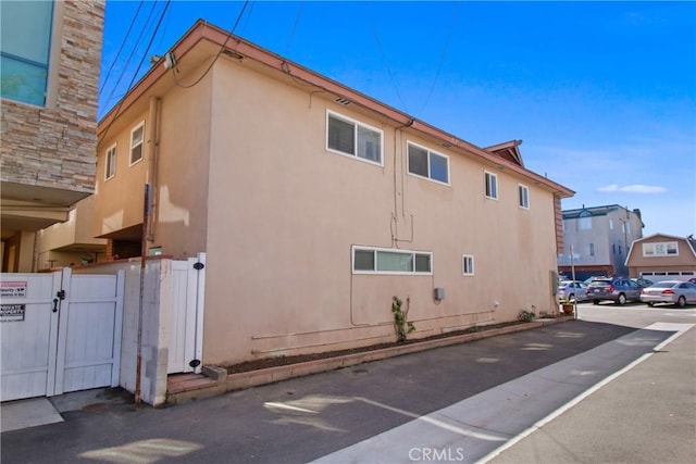 view of side of property with fence and stucco siding