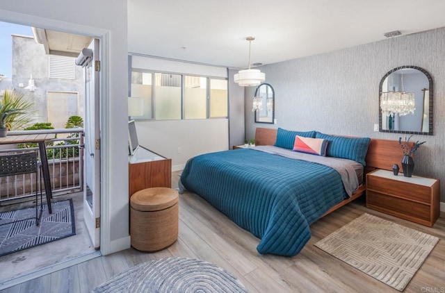 bedroom with access to exterior, visible vents, wallpapered walls, baseboards, and wood finished floors