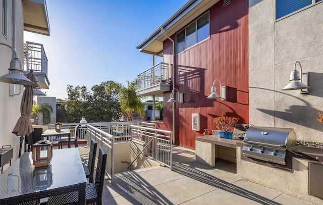 view of patio featuring area for grilling, a balcony, and a grill