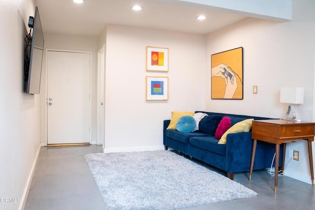 living room featuring recessed lighting, finished concrete flooring, and baseboards