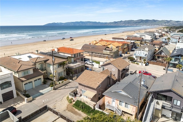 bird's eye view featuring a residential view, a water and mountain view, and a view of the beach