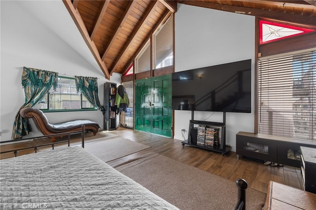 living area with beamed ceiling, wood finished floors, high vaulted ceiling, and a healthy amount of sunlight