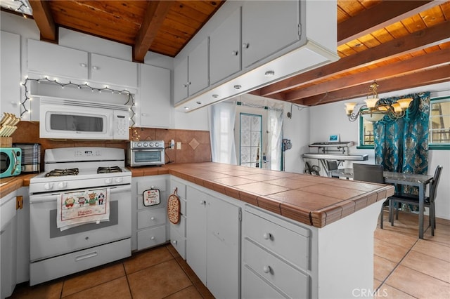 kitchen with beam ceiling, white appliances, an inviting chandelier, a peninsula, and decorative backsplash