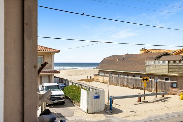 view of water feature with fence and a beach view