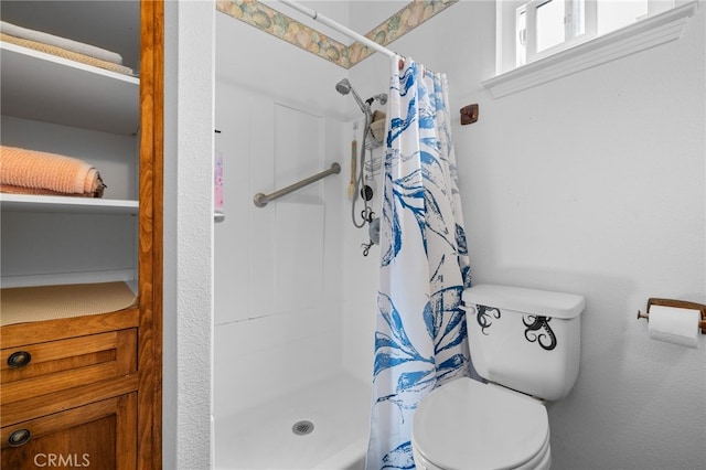 bathroom featuring a shower stall and toilet