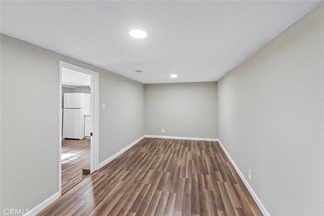 spare room featuring wood finished floors and baseboards