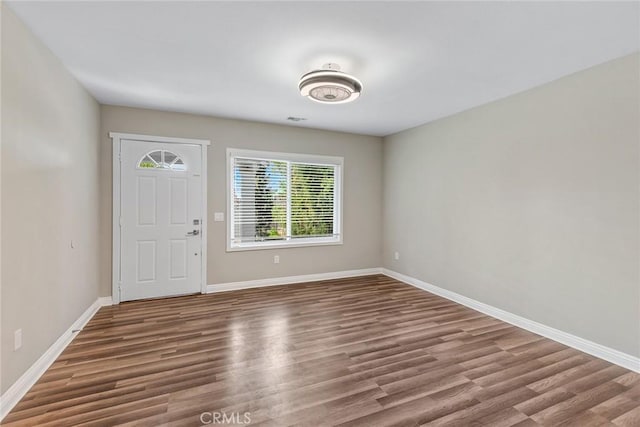 foyer entrance with visible vents, wood finished floors, and baseboards