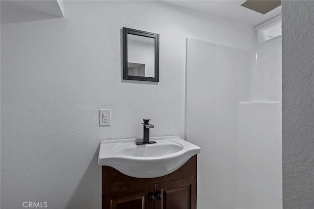 bathroom featuring vanity and a textured wall