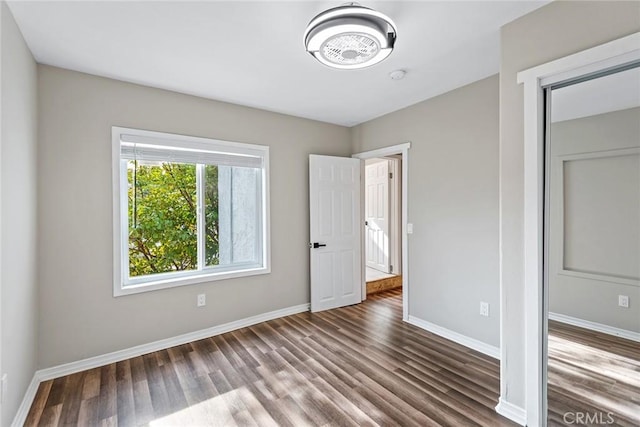 unfurnished bedroom with baseboards and wood finished floors