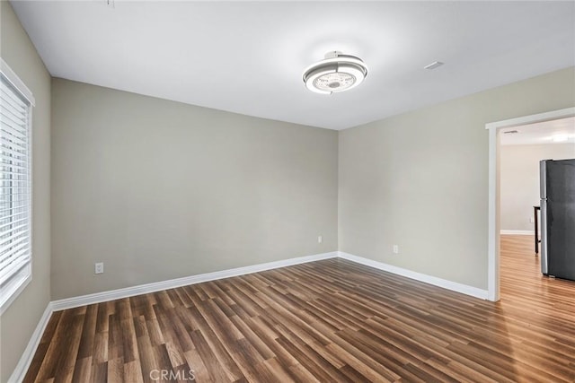 unfurnished room with baseboards and wood finished floors