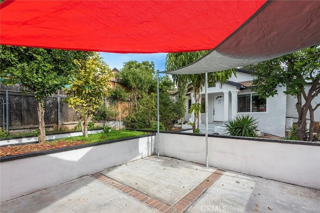 view of patio featuring a carport and fence