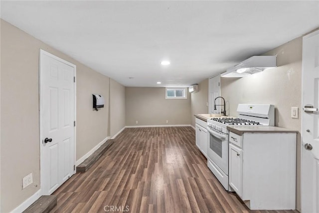 kitchen featuring white gas stove, a sink, dark wood-type flooring, white cabinets, and exhaust hood