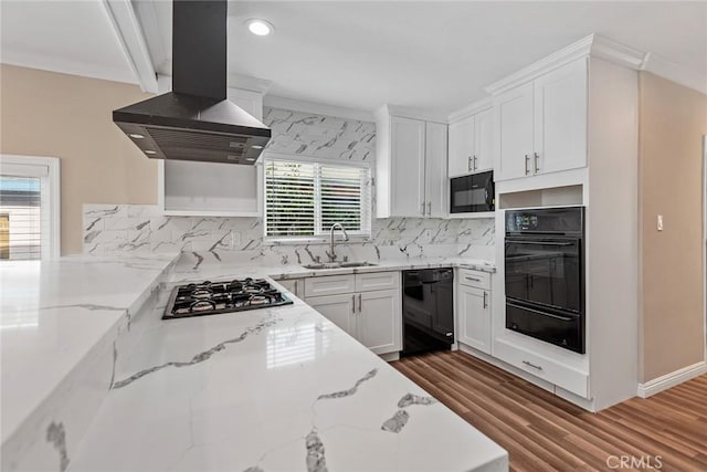 kitchen with a warming drawer, black appliances, ornamental molding, island exhaust hood, and a sink