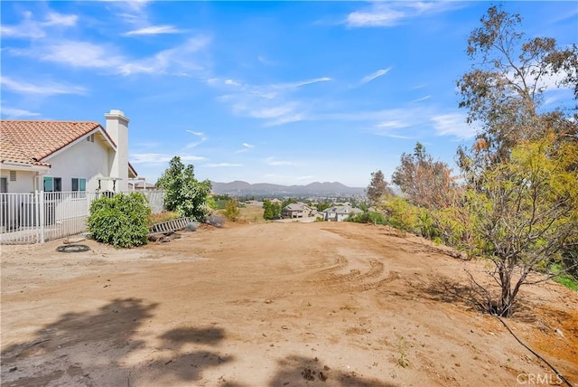 view of yard featuring a mountain view and fence