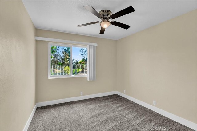 carpeted spare room with baseboards and ceiling fan