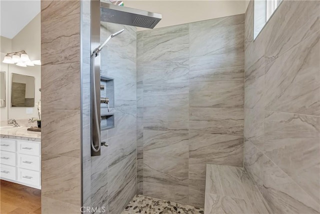 full bath featuring wood finished floors, vanity, and a walk in shower