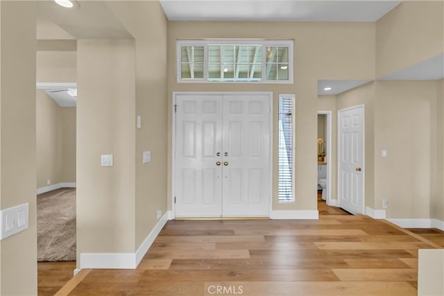 foyer with baseboards and light wood-type flooring