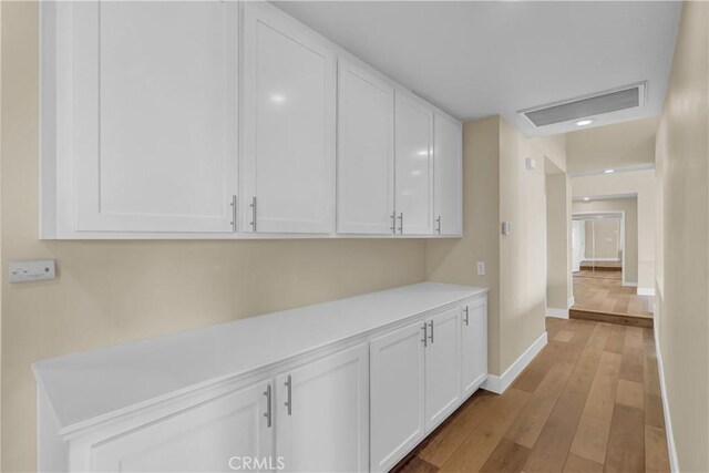 hall with light wood-style flooring and baseboards