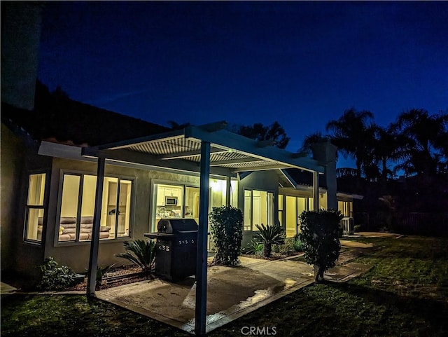 patio at night featuring grilling area