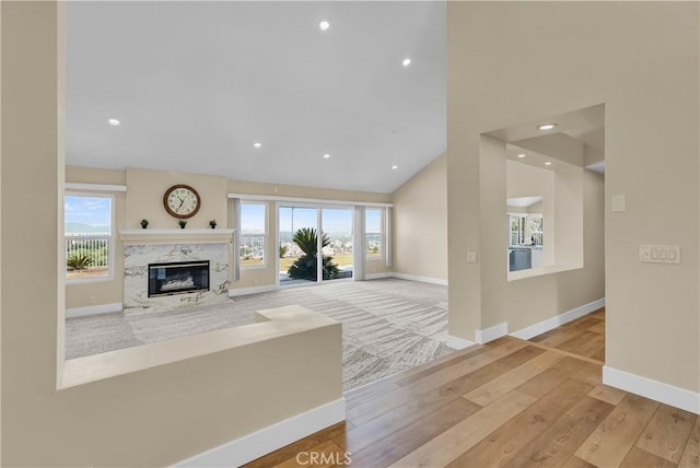 unfurnished living room with a wealth of natural light, baseboards, and wood finished floors