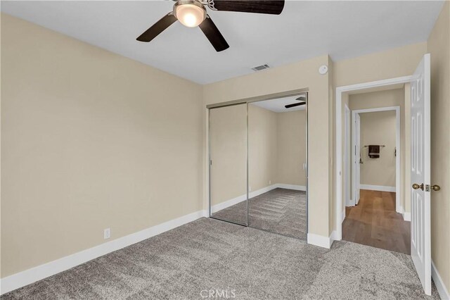 unfurnished bedroom with visible vents, baseboards, carpet flooring, a closet, and a ceiling fan