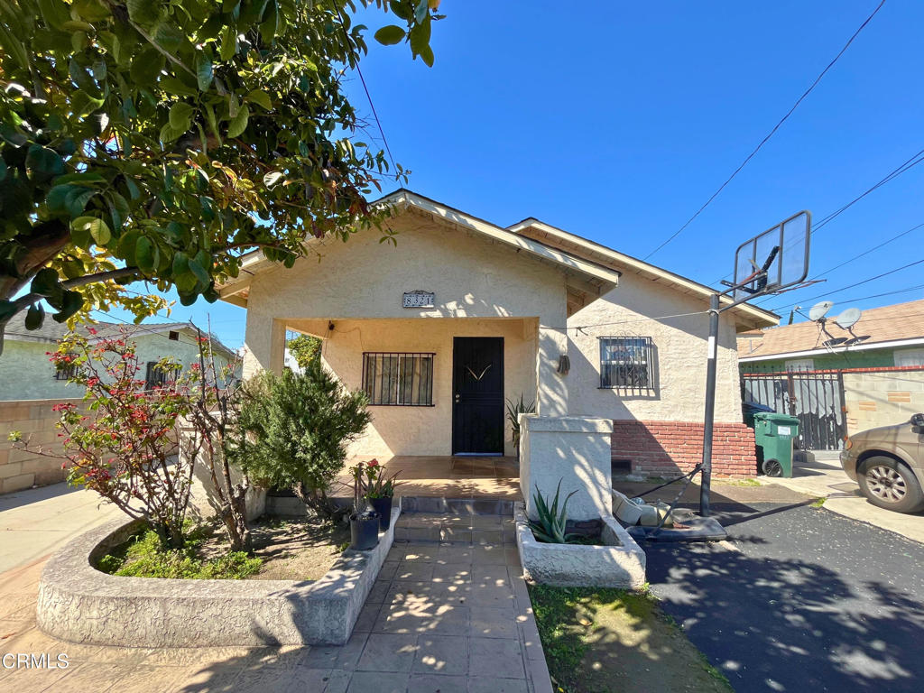 view of front of property featuring stucco siding, a porch, and fence