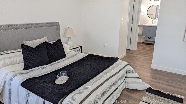 bedroom with wood finished floors and baseboards