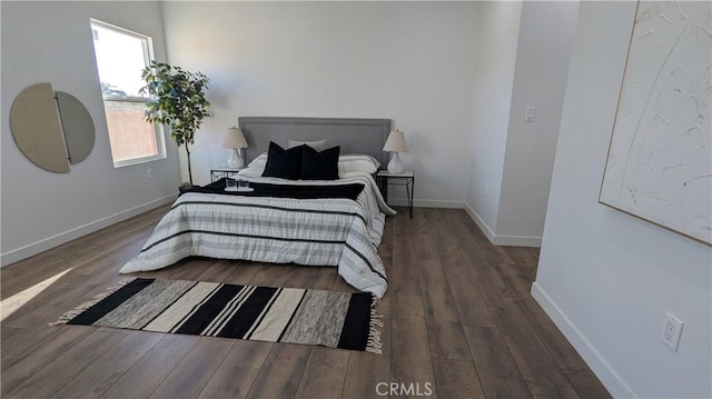 bedroom with baseboards and wood finished floors