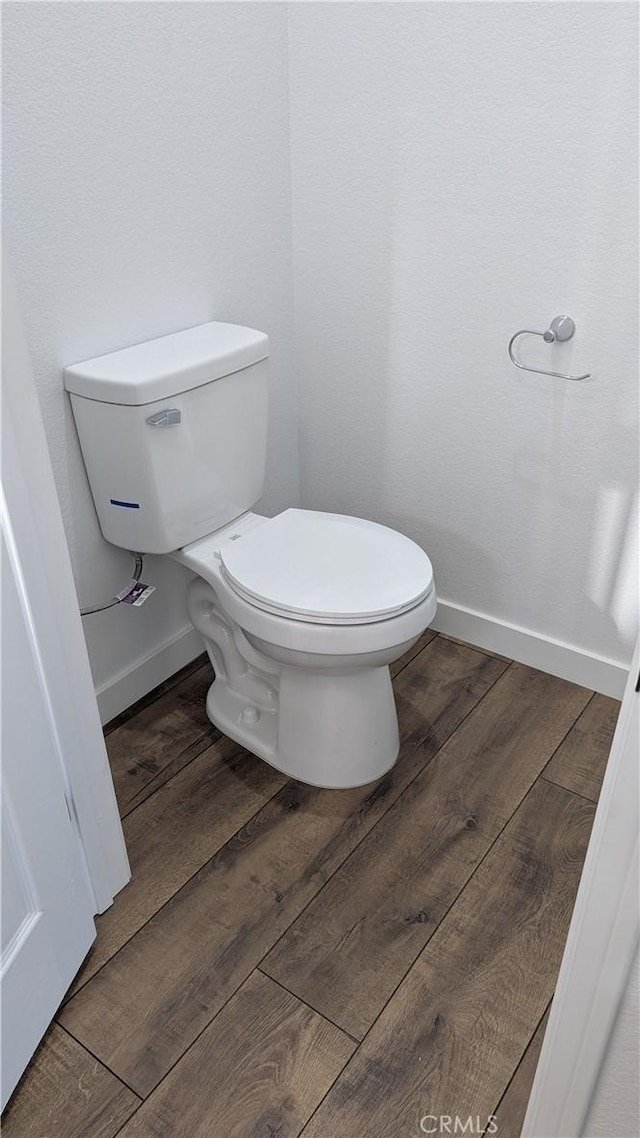 bathroom featuring toilet, baseboards, and wood finished floors