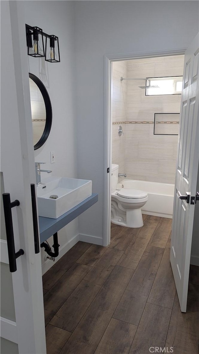 full bathroom featuring a sink, toilet, wood finished floors, and shower / bath combination