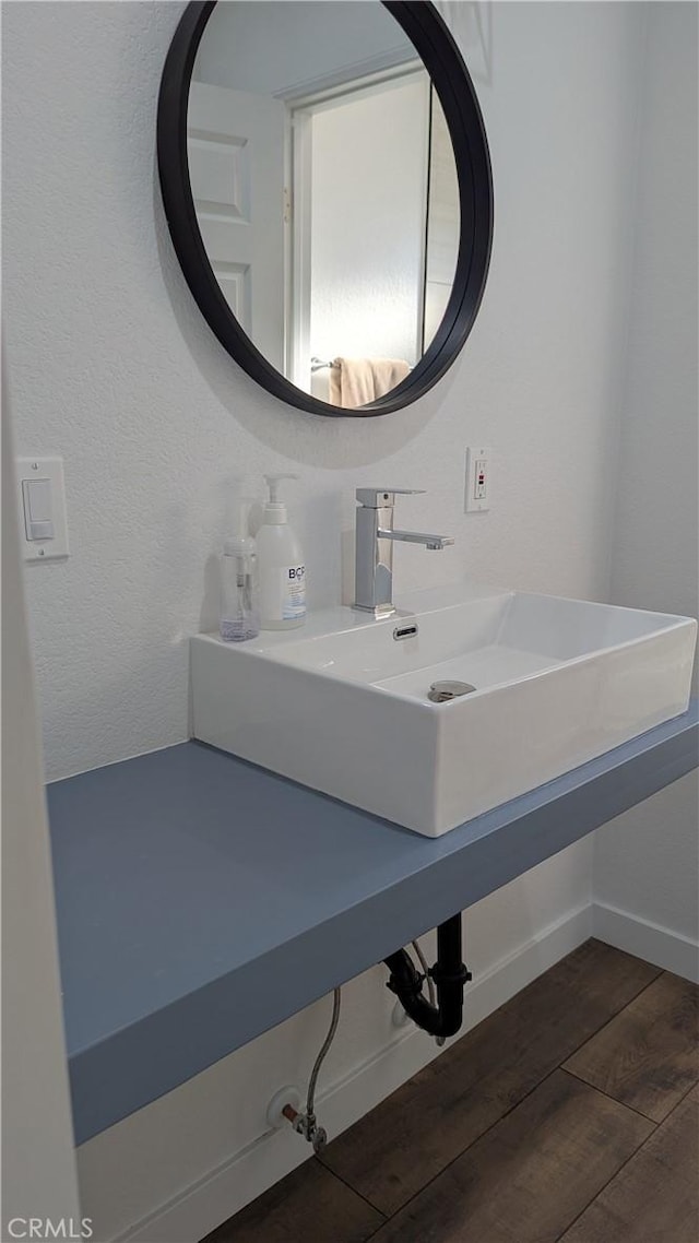 bathroom featuring a sink, baseboards, and wood finished floors