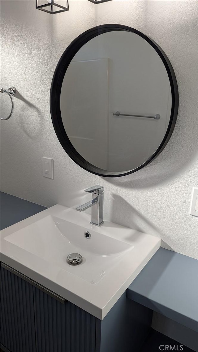 bathroom with vanity and a textured wall