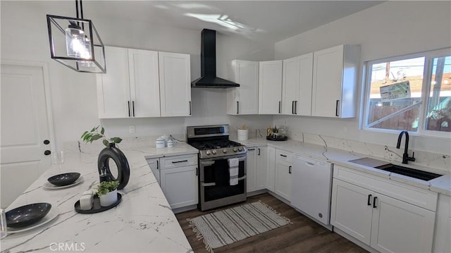 kitchen featuring double oven range, white dishwasher, a sink, white cabinetry, and wall chimney exhaust hood