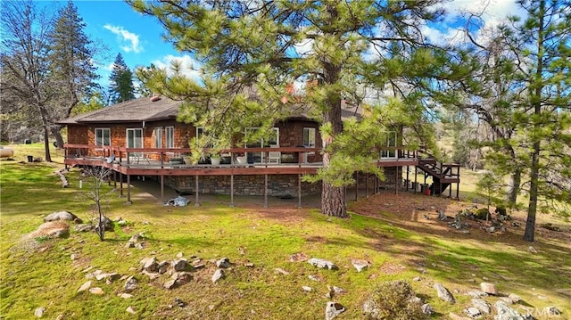 rear view of house with stairway, a lawn, and a deck