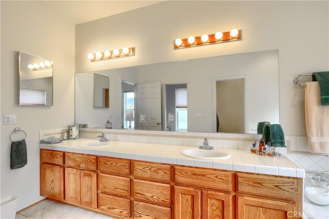 full bath with tile patterned flooring, double vanity, and a sink