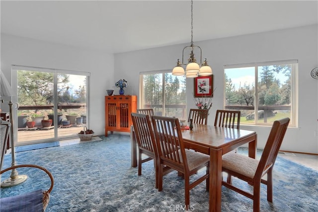 carpeted dining room featuring an inviting chandelier