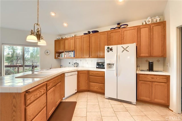 kitchen with tile countertops, lofted ceiling, a peninsula, white appliances, and a sink