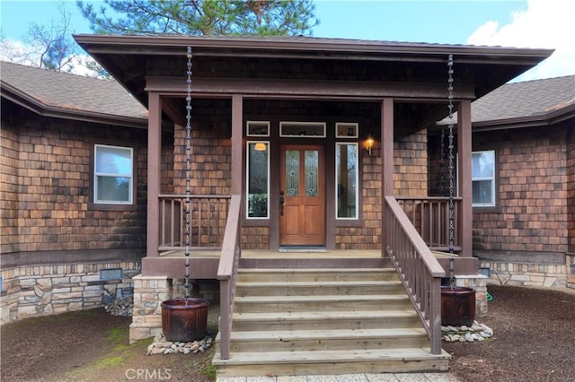 property entrance with covered porch, roof with shingles, and crawl space