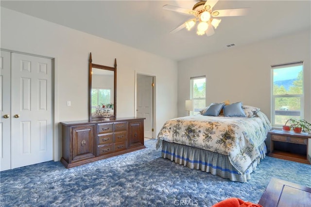 carpeted bedroom featuring a closet, visible vents, and ceiling fan