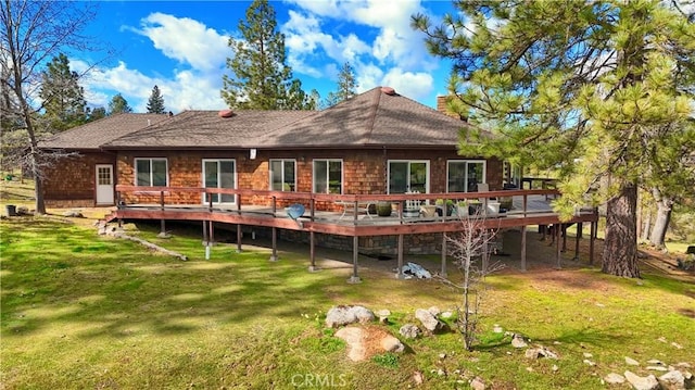 rear view of house featuring a lawn, a chimney, and a deck