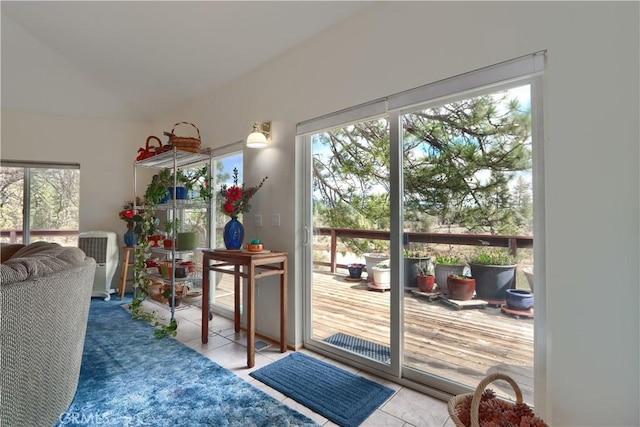 doorway to outside featuring tile patterned flooring and vaulted ceiling