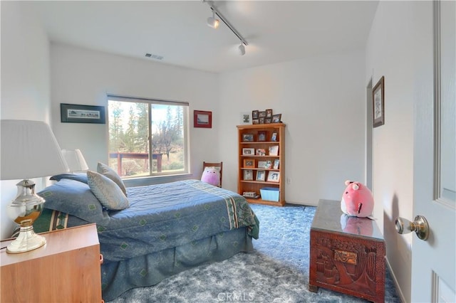 bedroom with track lighting, carpet, and visible vents