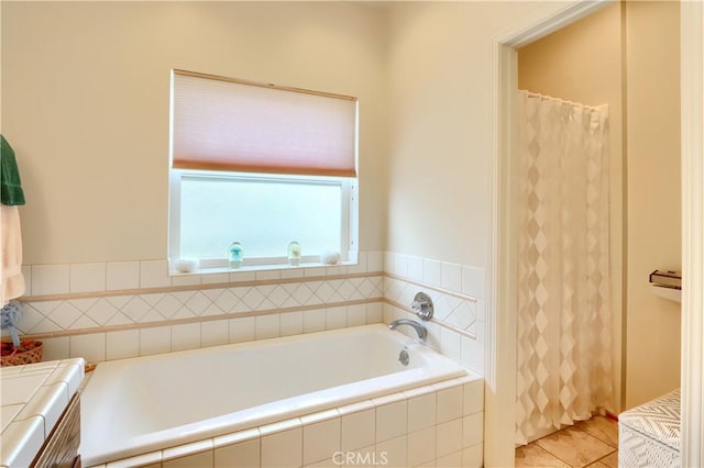 bathroom with tile patterned floors and a bath