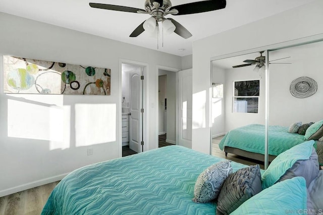 bedroom with a ceiling fan, wood finished floors, a closet, and baseboards