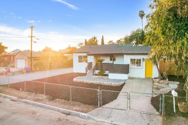 view of front of property featuring a gate, a fenced front yard, and stucco siding