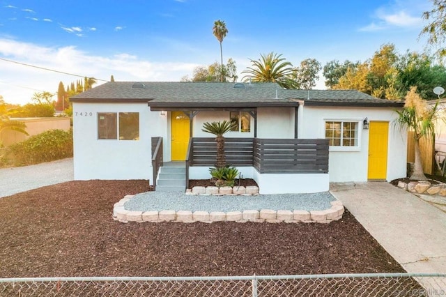 single story home featuring stucco siding, fence, and a shingled roof