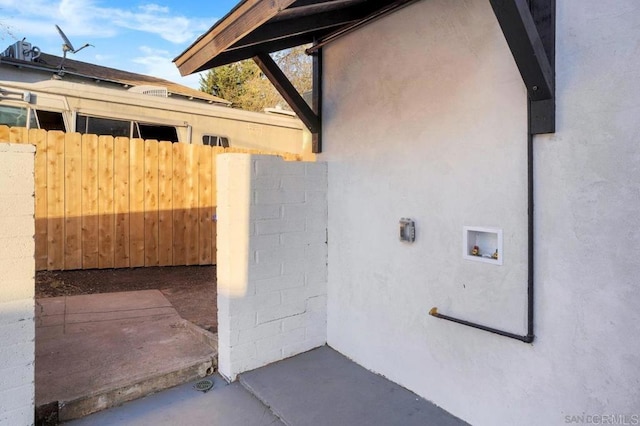 view of exterior entry featuring fence and stucco siding