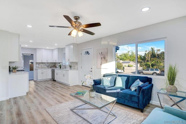 living room with light wood finished floors, recessed lighting, baseboards, and a ceiling fan