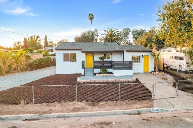 view of front of home with a fenced front yard, stucco siding, and a gate