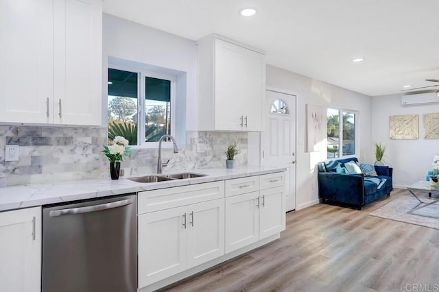 kitchen with light wood-style flooring, a sink, open floor plan, white cabinetry, and dishwasher